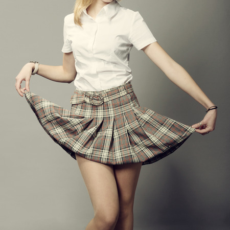 young lady lifting up her short plaid skirt の写真素材