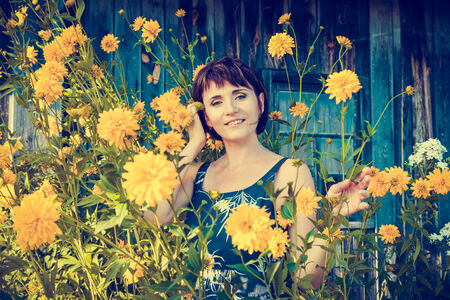 beautiful woman near yellow summer flowersの写真素材