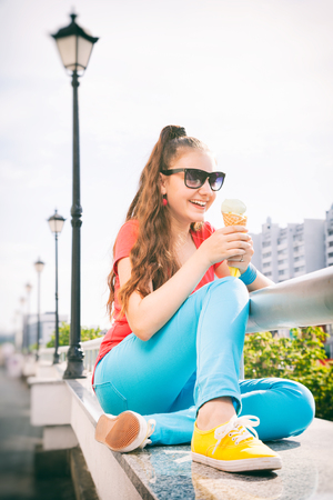 adorable teenager girl having fun and eating ice creamの写真素材