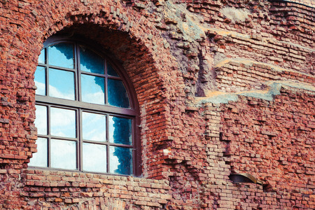 arched window in a aged red brick wallの写真素材