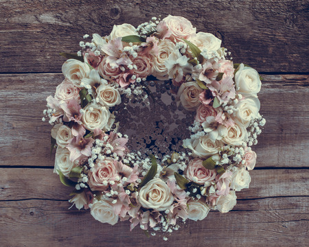 Roses wreath on wooden background. Retro stylized.の写真素材