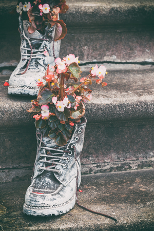 Old boots with flowers as element of garden design. Selective focus.の写真素材