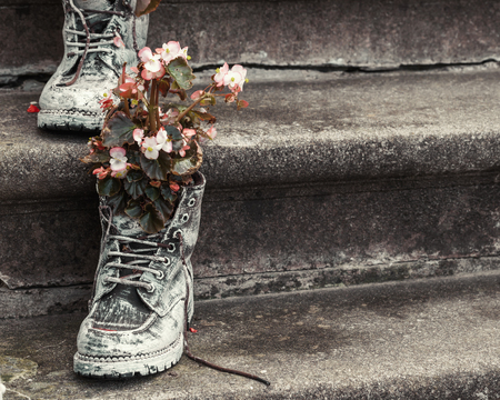 Old boots with flowers on stairs as element of garden design. Selective focus.の写真素材