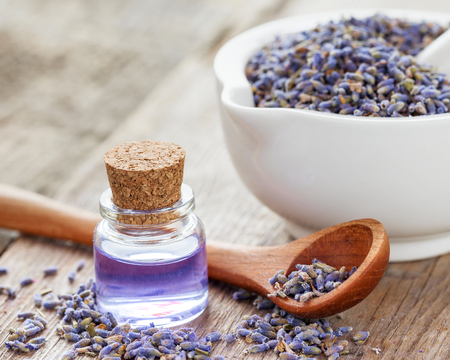Dry lavender flowers in mortar and bottle of essential oil. Selective focus.の写真素材