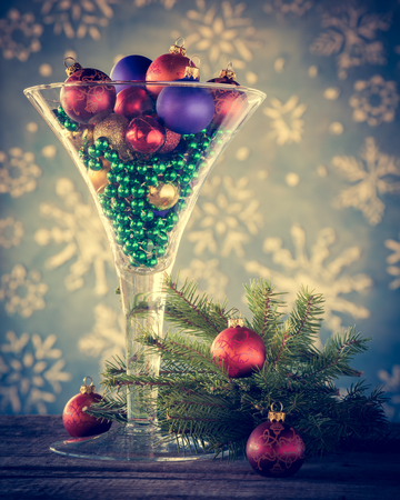 Christmas decoration - Wine glass filled with christmas tree balls as festive cocktail. Retro styled.の写真素材