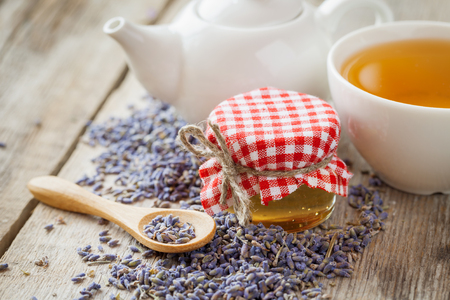 Jar of honey, dry lavender flowers, tea cup and teapot on background. Selective focus.の写真素材