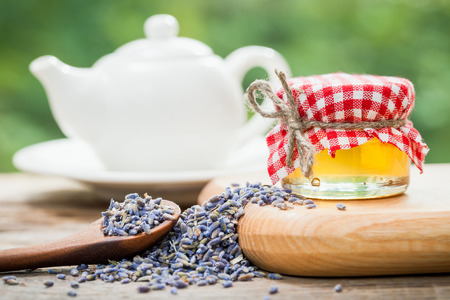 Jar of honey, dry healthy lavender tea and teapot on background. Selective focus.の写真素材