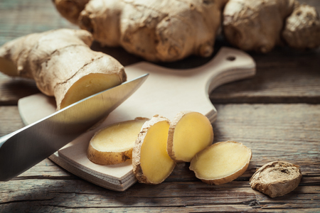 Chopped ginger root on cutting board on rustic wooden rustic table. Selective focus.の写真素材