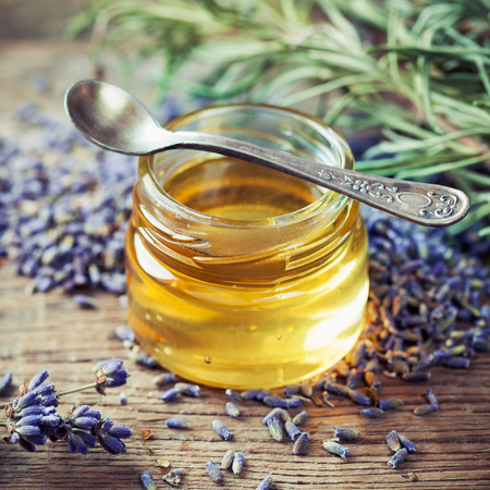 Jar of honey, spoon and dry lavender flowers for tea. Selective focus.の写真素材