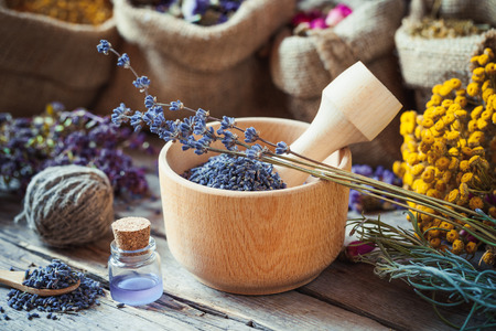 Healing herbs in hessian bags, wooden mortar with lavender flowers, bottles with tincture, herbal medicine. Selective focus.の写真素材