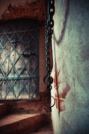 Fragment of medieval dungeon prison. Focus on ancient door.の写真素材