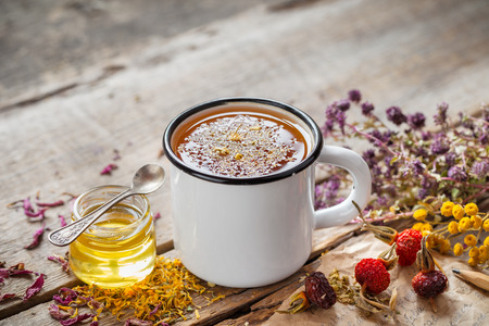 Cup of healthy daisy tea, honey and healing herbs on table. Herbal medicine.の写真素材