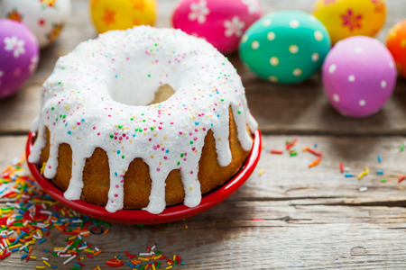 Easter cake and colorful eggs on old rustic table.