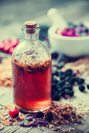 Tincture bottle and mortar of healing herbs on background. Herbal medicine.の写真素材