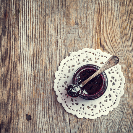Jar of jam with spoon on old wooden table. Top view.の写真素材