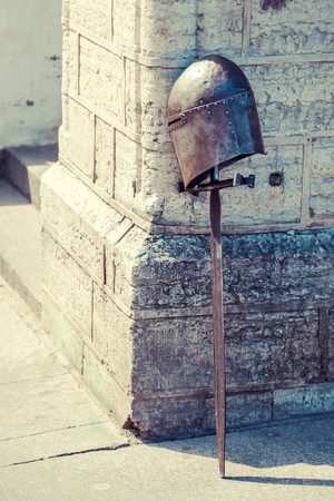 Helmet and sword of the knight standing at the medieval wallの写真素材