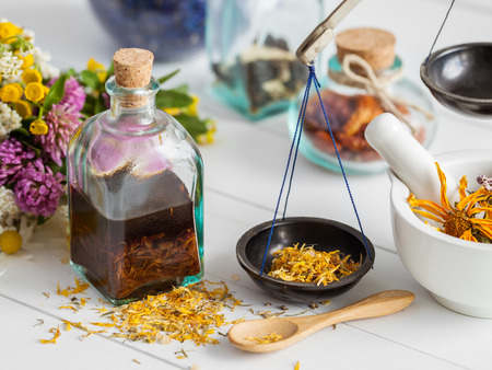 Bottles of tincture and healthy herbs, mortar on table. Herbal medicine. Selective focus.の写真素材