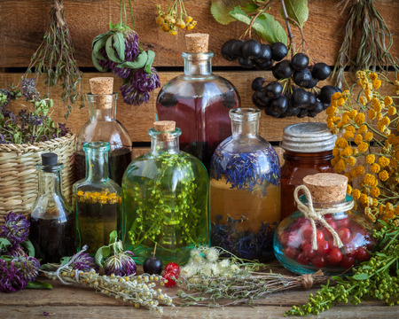 Bottles of tincture, potion, oil, healthy berries and healing herbs. Herbal medicine.の写真素材
