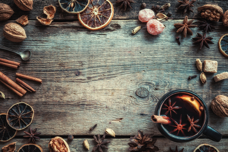 Mulled wine in rustic mug with spices and ingredients on wooden background. Top view, flat lay. Retro styled photo. Copy space for your text.の写真素材