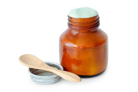 A balm jar full of medicated ointment in green color and spoon on white background.の写真素材