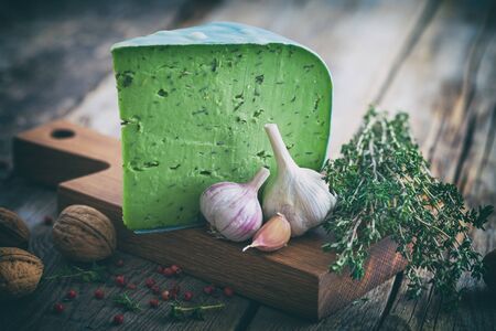 Green cheese with herbs and spices on cutting board. Retro toned.の写真素材