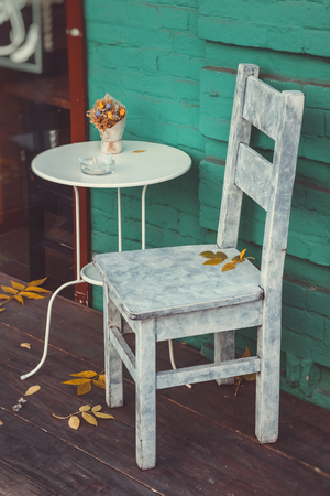 Fragment of vintage cafe - retro chair and table for smokers. Retro toned photo.の写真素材