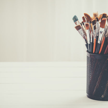 Paint brushes in a artist studio. Copy space for your text. Retro toned photo.の写真素材