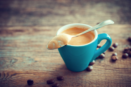 Espresso coffee cup and beans on wooden board. Retro stylized.の写真素材