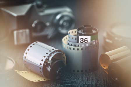 Old photo film rolls and retro camera on background. Vintage stylized with a glow effect.の写真素材
