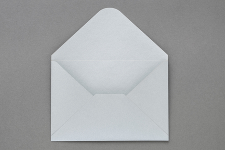 Open gray envelope on dark gray background.の写真素材