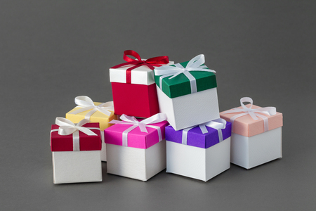 Several colorful gift boxes with ribbons on gray background. の写真素材