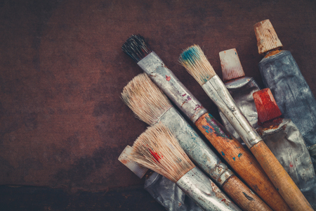 Artist paintbrushes, paint tubes closeup on brown canvas background. Copy space for text.の写真素材