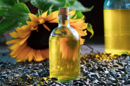 Bottle of fresh sunflower oil, seeds and  sunflower on background.の写真素材