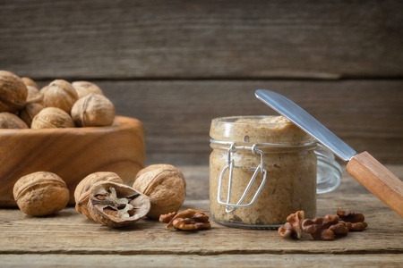 Jar of raw organic walnut butter and fresh nuts on table. Copy space for text.の写真素材