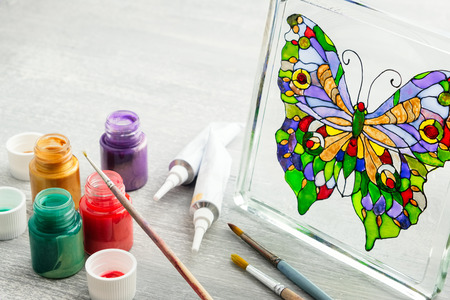Artisan painting with stained glass paints on the glass surface.の写真素材