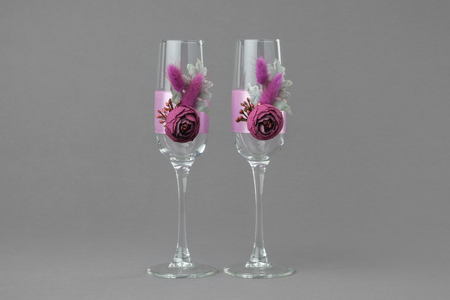 Two decorated wedding wine glasses on grayの写真素材