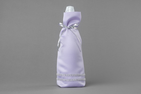 Decorated wedding champagne bottle  in bag on grayの写真素材