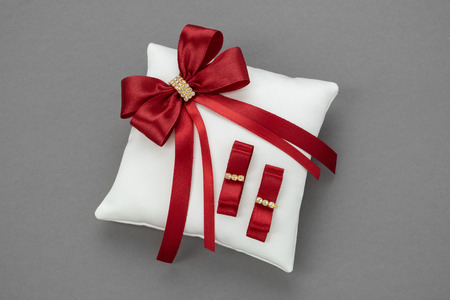 Wedding Pillow for Rings decorated with red ribbons.の写真素材