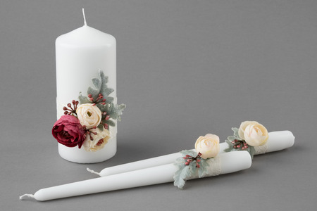 Three candles decorated with flowers on grayの写真素材