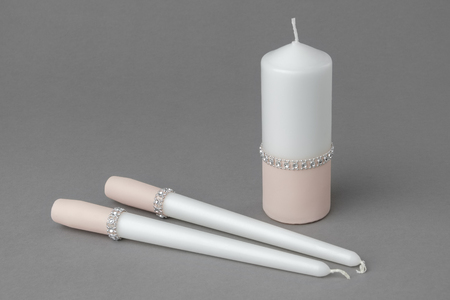 Three candles decorated with cloth in cream color.の写真素材