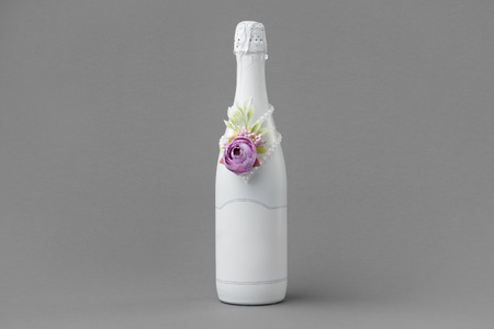 Wedding champagne bottle with blank label. Bottle decorated with roses, pearls and ribbon. Copy space for text.の写真素材
