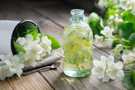 A bottle of garden jasmine oil and philadelphus coronarius flowers.の写真素材