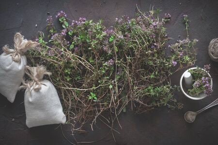 Thyme flowers, mortar and sachets full of thymus serpyllum medicinal herbs. Top view.の写真素材