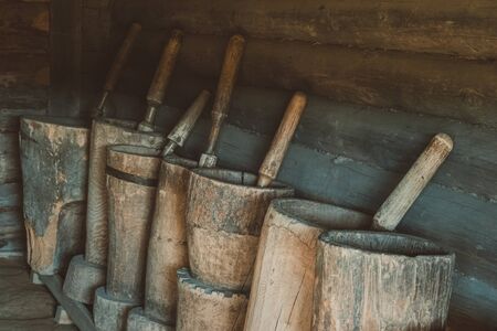 Old wooden mortars with pistils in them. Old home utensils  for grains grinding.の写真素材