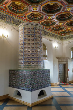 Mir, Belarus -  23-October-2019: ornate retro tiled stove and decorated carved ceiling in vintage dinner room at exposition in Mir castle. Mir, Grodno region, Belarus.のeditorial素材