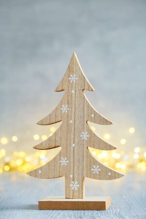 Wooden christmas tree and christmas lights on background.  Greeting card.の写真素材