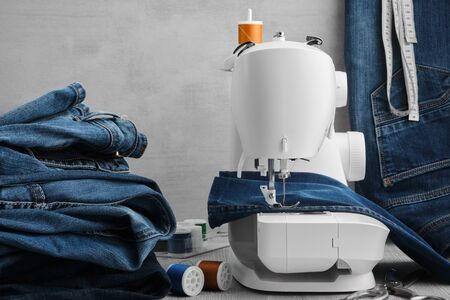 Sewing denim jeans on sewing machine in tailor workshop.の写真素材