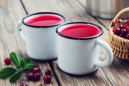 Two enameled mugs of or cranberry juiceの写真素材