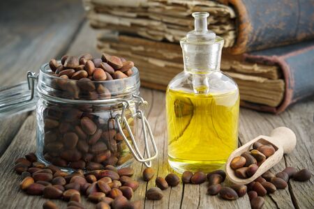 Pine nuts and pine nuts essential oil bottle on wooden table. の写真素材