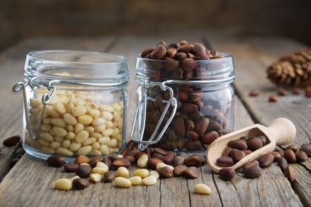 Pine nuts. Jars of cedar pine nuts on table.の写真素材